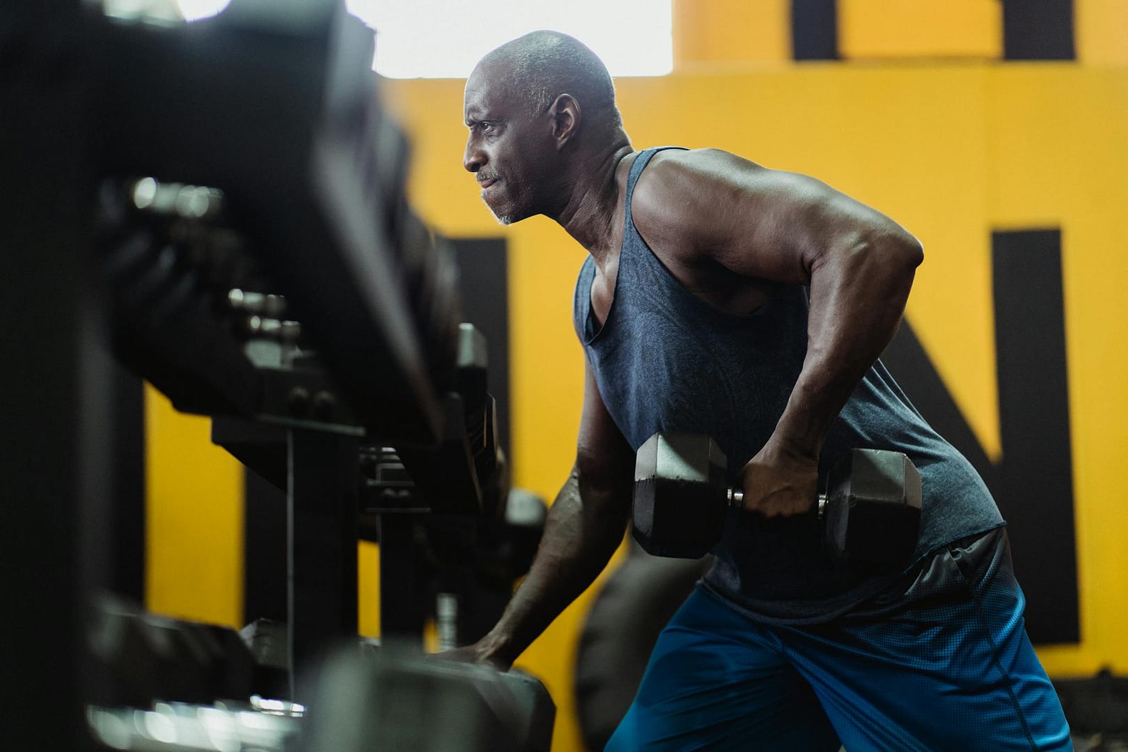Athlete lifting dumbbells in gym, showcasing strength and determination.